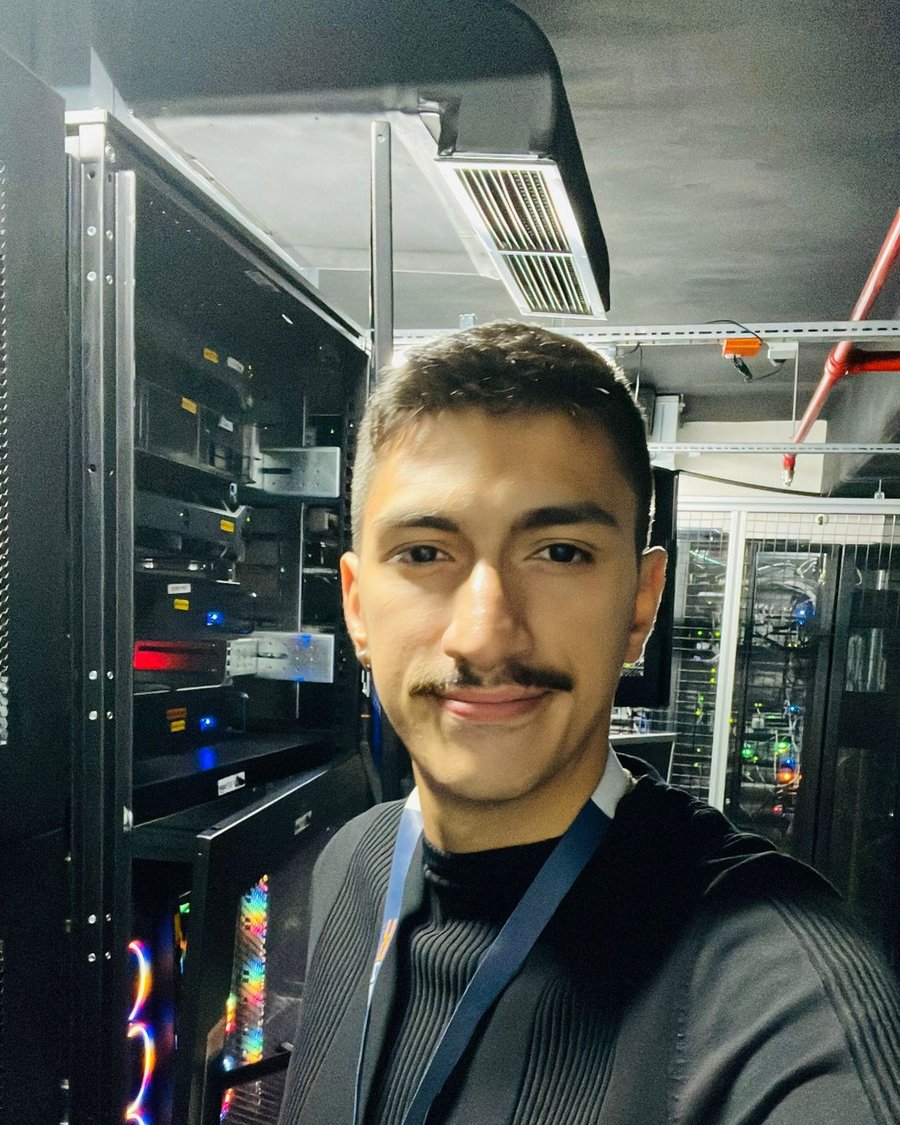 Batuhan Uğurlu, veri merkezinde sunucu rafları önünde